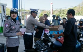 Personel Satlantas Polres Barru memantau antrean pengisian BBM sekaligus memberikan makanan ringan kepada pengendara di SPBU Siawung, Kecamatan Barru, Kabupaten Barru, Senin (14/9/2026).