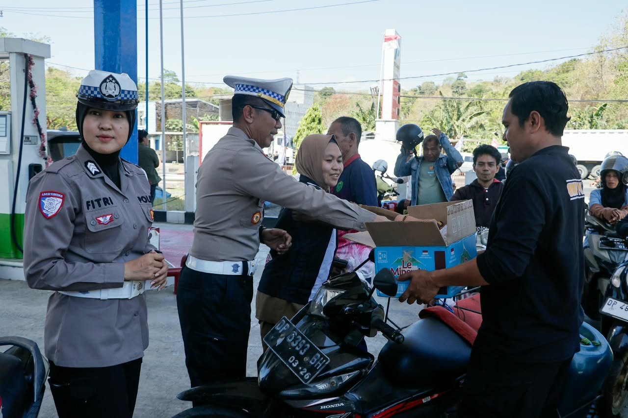 Personel Satlantas Polres Barru memantau antrean pengisian BBM sekaligus memberikan makanan ringan kepada pengendara di SPBU Siawung, Kecamatan Barru, Kabupaten Barru, Senin (14/9/2026).