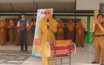 Kepala UPTD SPF SMP Negeri 15 Makassar, Mutmainah, S.Pd., M.Pd., saat memperkenalkan inovasi pembelajaran TULISKA (Target Ucap & Latih Bahasa Inggris Setiap Pekan) dalam kegiatan launching di halaman sekolah, Senin (28/9/2026).