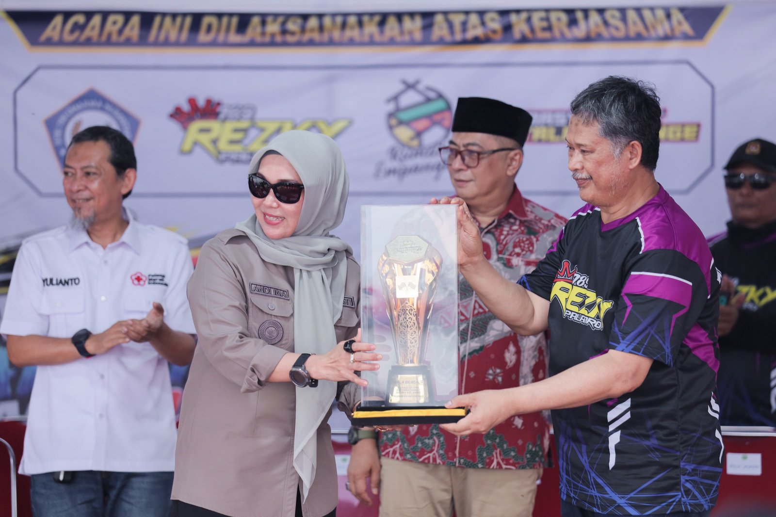 Bupati Barru, Andi Ina Kartika Sari, menerima penyerahan piala bergilir Palanro Katinting Race 2026 dari perwakilan panitia di Pantai Pattalellangge, Kelurahan Palanro, Kecamatan Mallusetasi, Jumat (23/10/2026). (Foto: Istimewa)